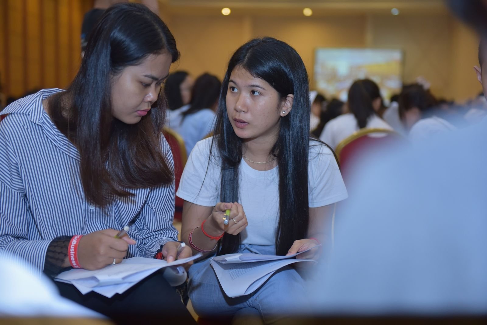 Two participants closely discussing a worksheet during a training session