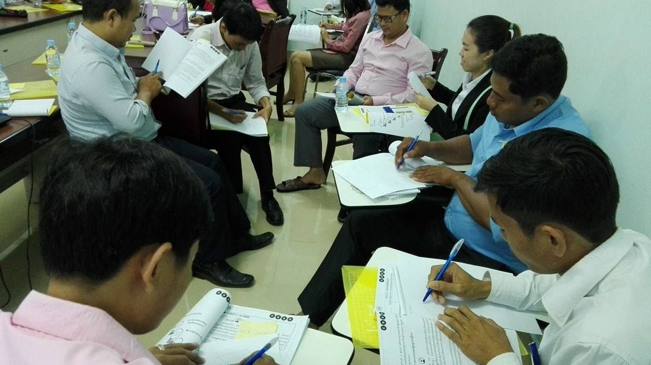 A small group reviewing factory-improvement worksheets together