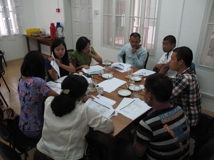 A group seated around a table working through printed FIT materials
