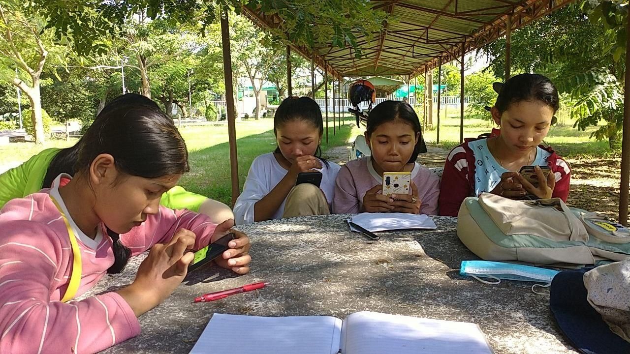 A group of young women reviewing ABL notes together outdoors