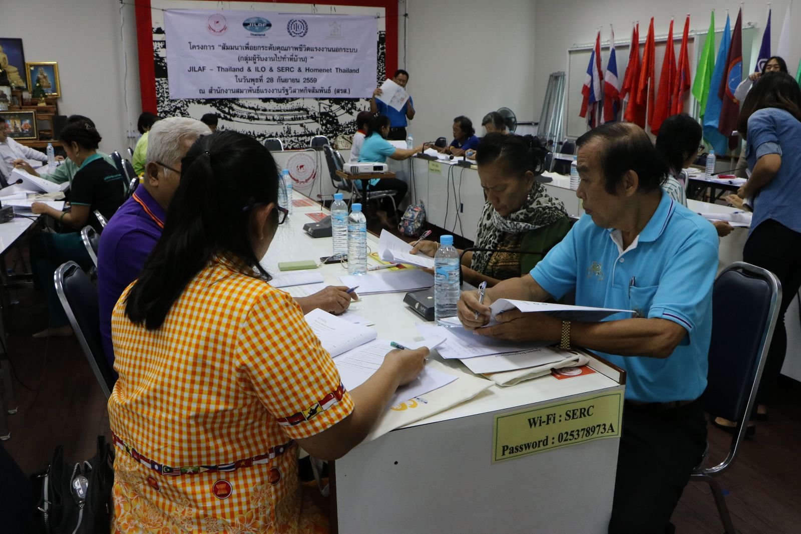Participants in Thailand reviewing training materials at an ILO and JILAF session for informal-economy homeworkers